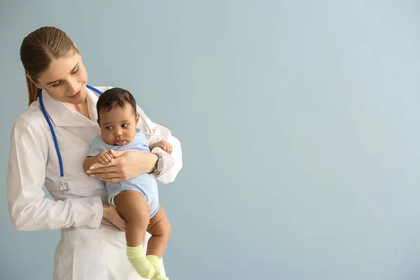 Pediatra con bambino afro-americano su sfondo colore — Foto Stock