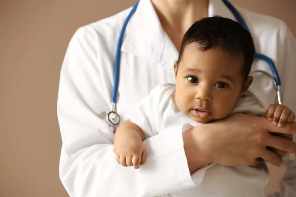 Pediatra con bebé afroamericano sobre fondo de color —  Fotos de Stock