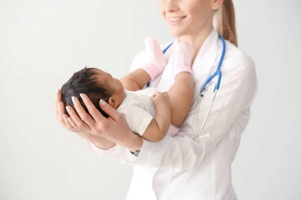 Pediatra z Afro-baby na jasnym tle — Zdjęcie stockowe