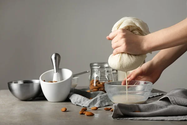 Woman making healthy almond milk in kitchen — Stock Photo, Image