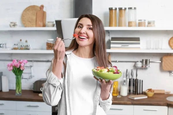 Evde mutfakta sağlıklı salata yeme güzel kadın — Stok fotoğraf