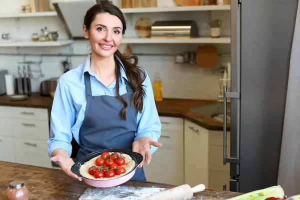 Hermosa mujer cocinando pastel de verduras en la cocina en casa —  Fotos de Stock