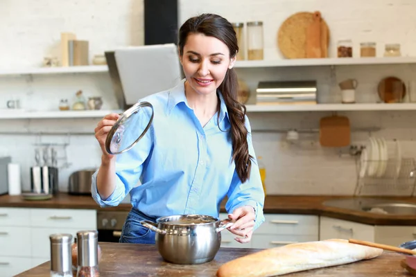 Beautiful woman with tasty hot soup in kitchen at home — Stock Photo, Image