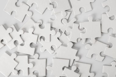 Işık arka plan üzerinde beyaz puzzle parçaları yığını