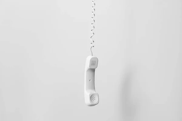 Hanging telephone receiver on white background — Stock Photo, Image