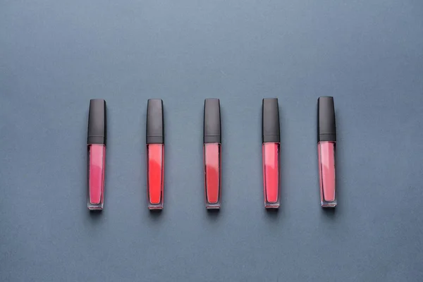 Different lipsticks on grey background — Stock Photo, Image