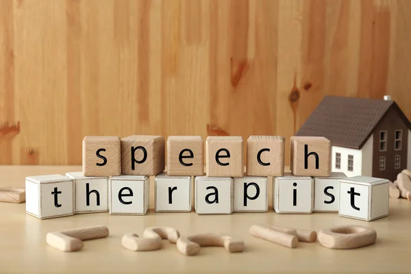 Cubes forming text SPEECH THERAPIST on table