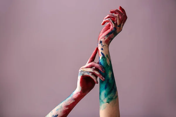 Painted female hands on color background — Stock Photo, Image