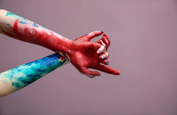 Painted female hands on color background — Stock Photo, Image