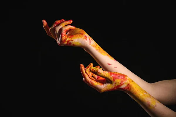 Painted female hands on dark background — Stock Photo, Image
