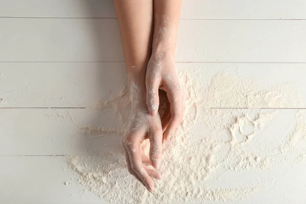 Руки женщины с мукой на белом столе — стоковое фото