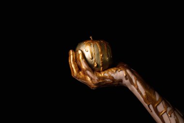 Koyu arka plana karşı elma ile boyalı el