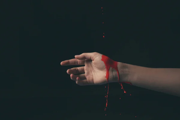 Kobieta ręka z nalewania farby na ciemnym tle — Zdjęcie stockowe