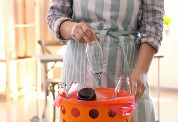 Frau wirft Glasflaschen in Mülleimer — Stockfoto