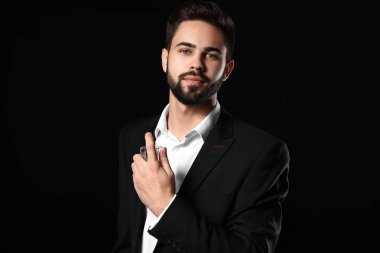 Yakışıklı adam koyu arka plan üzerinde parfüm şişe