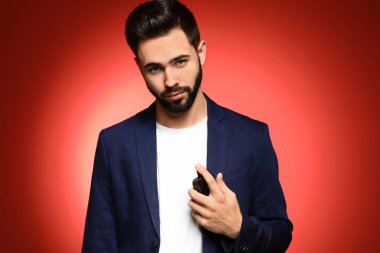 Renk arka plan üzerinde parfüm şişe yakışıklı adam