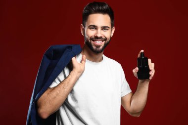 Renk arka plan üzerinde parfüm şişe yakışıklı adam