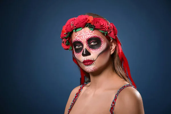 Mujer joven con el cráneo pintado en su cara para el Día de los Muertos de México contra el fondo de color — Foto de Stock