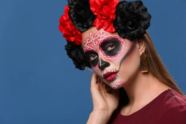Young woman with painted skull on her face for Mexico's Day of the Dead against color background — Stock Photo, Image