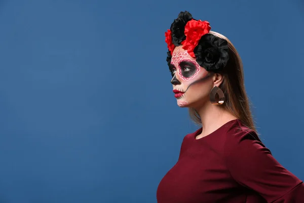 Ung kvinna med målade skalle på hennes ansikte för Mexikos Day of the Dead mot färg bakgrund — Stockfoto