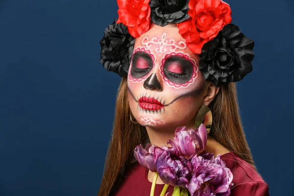 Young woman with painted skull on her face for Mexico's Day of the Dead against color background — Stock Photo, Image