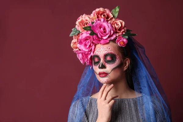 Mladá žena s malovanou lebkou na tváři pro Mexický den mrtvých na barevném pozadí — Stock fotografie
