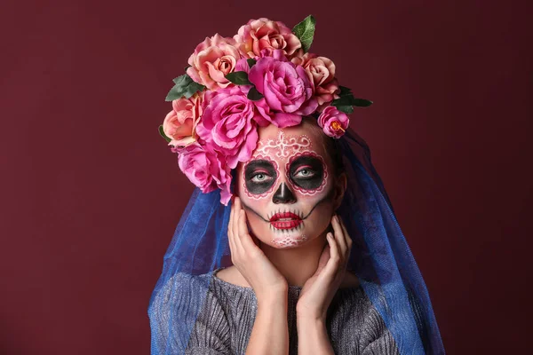Jonge vrouw met geschilderde schedel op haar gezicht voor Mexico 's Dag van de Doden tegen kleur achtergrond — Stockfoto