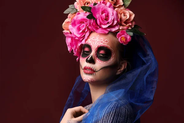 Young woman with painted skull on her face for Mexico's Day of the Dead against color background — Stock Photo, Image