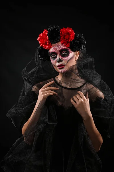 Junge Frau mit bemaltem Totenkopf im Gesicht zum mexikanischen Totentag vor dunklem Hintergrund — Stockfoto