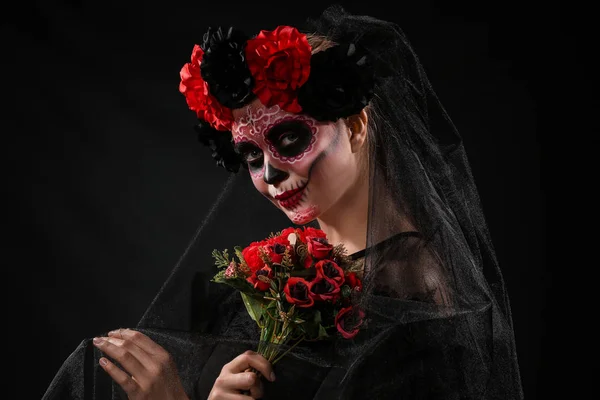 Junge Frau mit bemaltem Totenkopf im Gesicht zum mexikanischen Totentag vor dunklem Hintergrund — Stockfoto