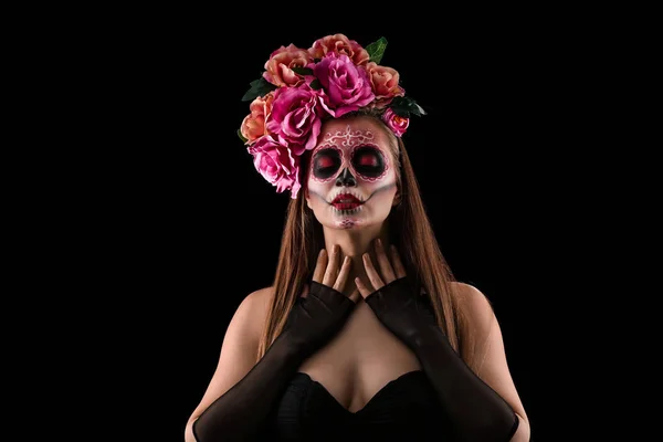 Jovem com crânio pintado em seu rosto para o Dia dos Mortos do México contra fundo escuro — Fotografia de Stock