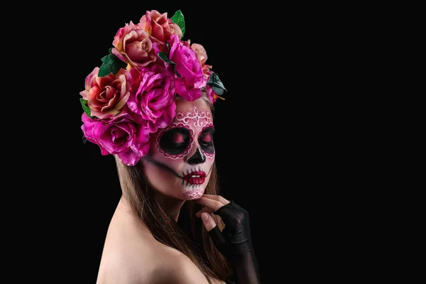 Mladá žena s malovanými lebky na její tvář pro mexický den mrtvých proti tmavým pozadím — Stock fotografie