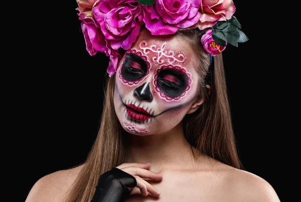 Young woman with painted skull on her face for Mexico's Day of the Dead against dark background — Stock Photo, Image