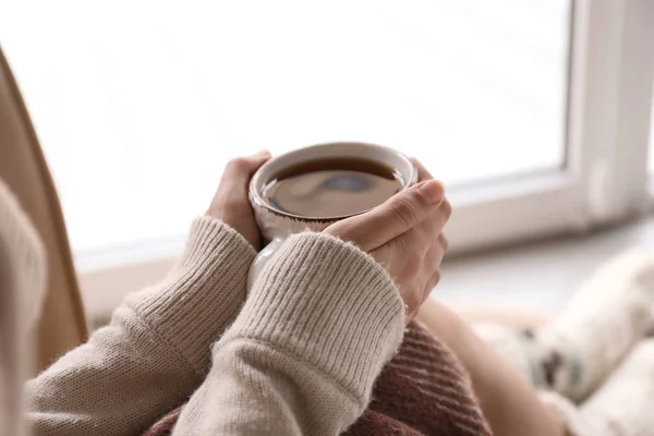 Молода жінка п'є гарячий чай вдома, крупним планом — стокове фото