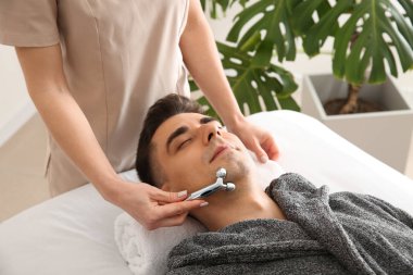 Güzellik salonunda yüz masaj alan adam