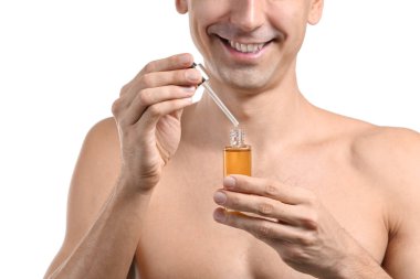 Beyaz arka plan üzerinde yüz serumu ile yakışıklı adam