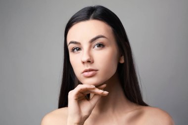 Gri arka plan üzerinde sağlıklı cilt ile güzel bir kadın portresi
