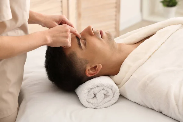 Чоловік отримує масаж обличчя в салоні краси — стокове фото