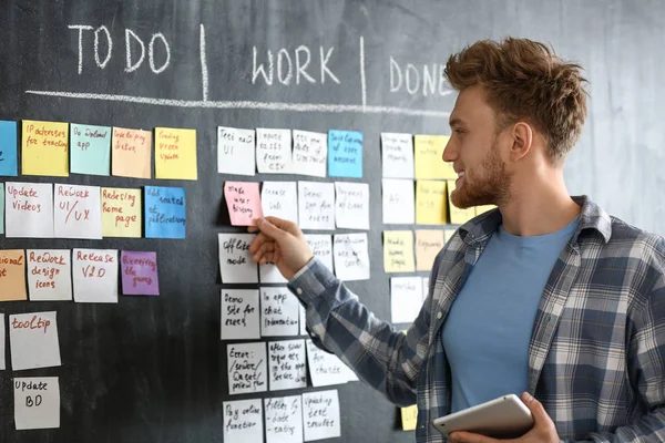 Young man near scrum task board in office — Stock Photo, Image