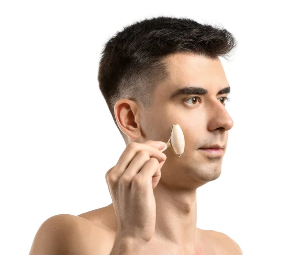 Man met gezichtsmassage tool op witte achtergrond — Stockfoto