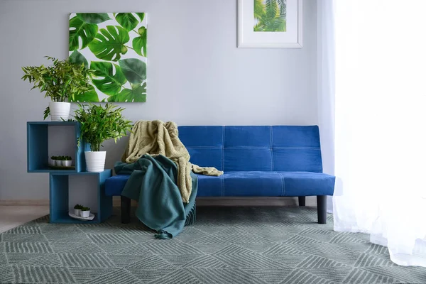 Stylish blue sofa in interior of living room — Stock Photo, Image