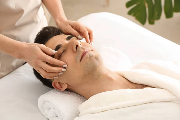 Hombre recibiendo masaje facial en salón de belleza —  Fotos de Stock