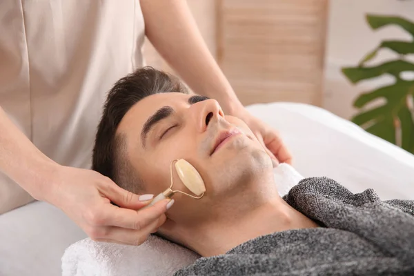 Hombre recibiendo masaje facial en salón de belleza — Foto de Stock