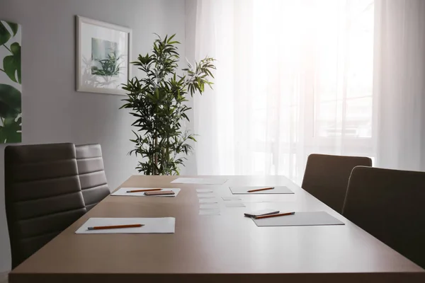 Mesa com artigos de papelaria preparados para reunião de negócios na sala de conferências — Fotografia de Stock