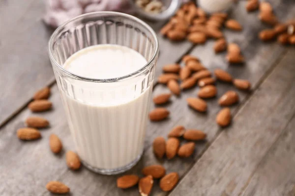 Glass of tasty almond milk on wooden table — Stock Photo, Image