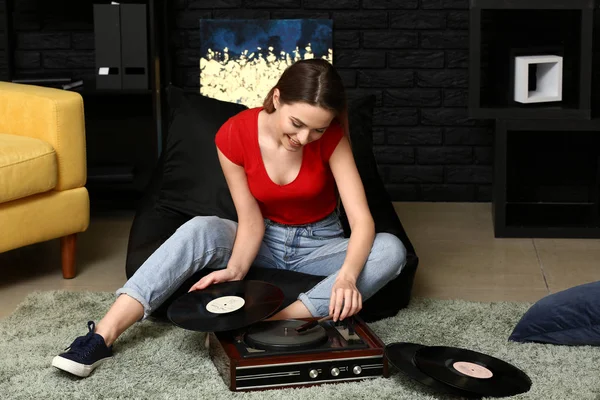 Mujer joven con viejo tocadiscos y discos de vinilo en casa — Foto de Stock