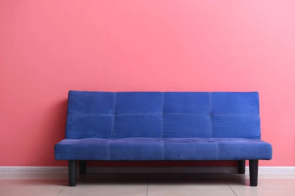 Κομψό μπλε καναπέ κοντά στον τοίχο χρώμα στο δωμάτιο — Φωτογραφία Αρχείου