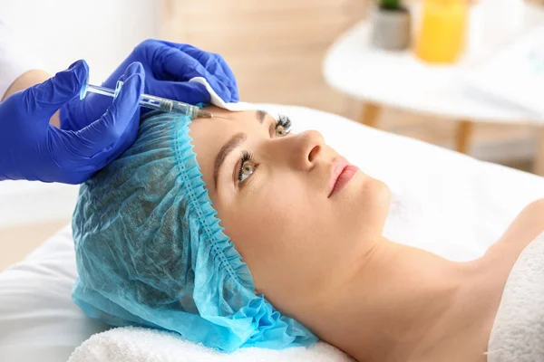 Young woman receiving filler injection in beauty salon — Stock Photo, Image