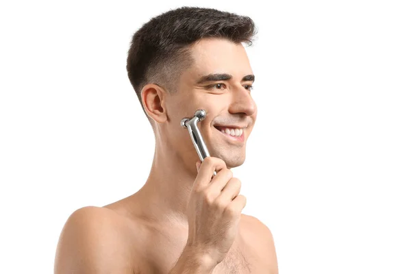 Man met gezichtsmassage tool op witte achtergrond — Stockfoto