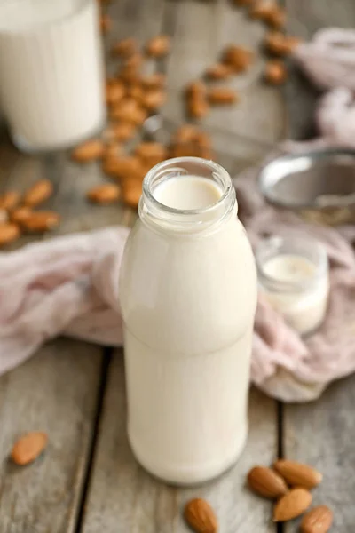 Bottle of tasty almond milk on wooden table — Stock Photo, Image